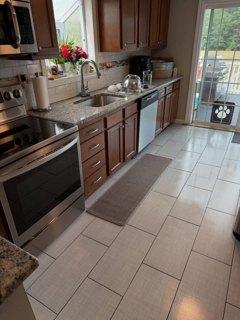 Clean kitchen with wood cabinets and tile floor after an Accurate Cleaning visit
